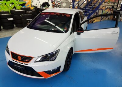Weisses Fahrzeug mit orangefarbener Teilfolierung