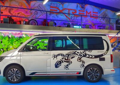 Weisser VW Bus mit individueller schwarzer Fahrzeugbeschriftung
