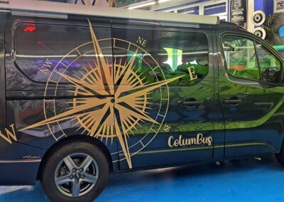 Dunkler VW Bus mit grosser Kompass-Fahrzeugfolierung