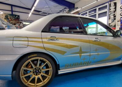 Silberne Limousine mit goldener und blauer Seitenfolierung
