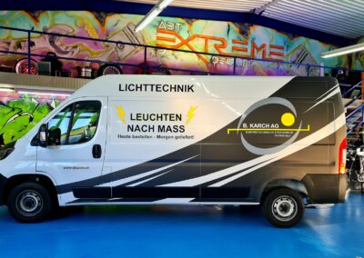 Weisser Transporter mit schwarzer Firmenbeschriftung für Lichttechnik