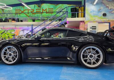 Schwarzer Porsche mit Sportfelgen in der Werkstatt